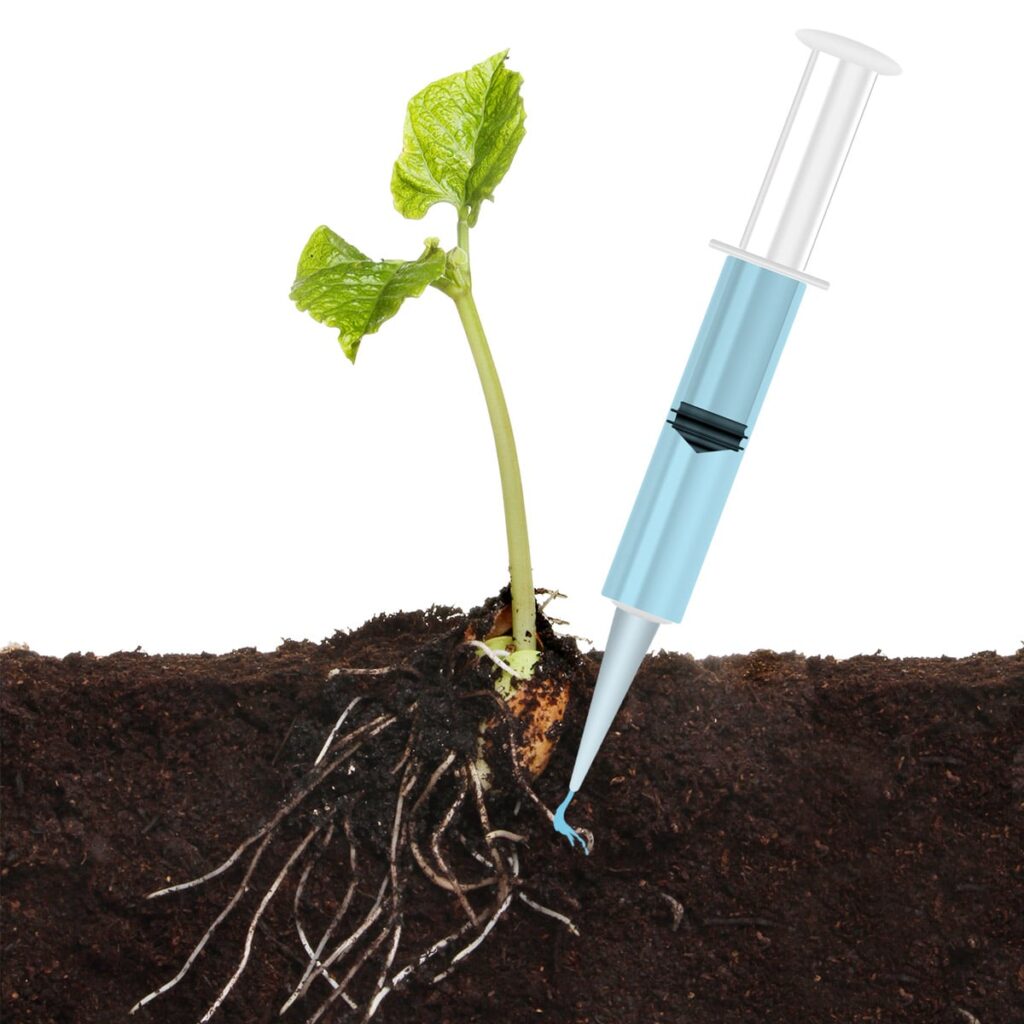 Syringe applying mycorrhizal fungi spores into the soil next to the roots